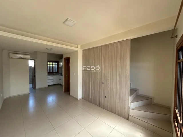 Hall de entrada com piso cerâmico e paredes brancas em uma propriedade.