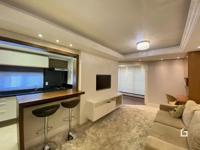 Sala de estar com móveis de madeira e sofá claro.