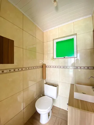 Foto de um banheiro interno com revestimento de cerâmica amarelada.