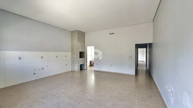 Ambiente interno amplo com paredes brancas e piso claro.