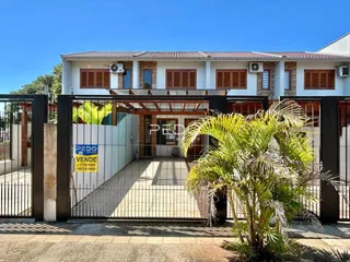 Fachada de uma residência em Lajeado, Brasil, com portão de ferro e vegetação.