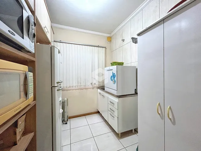 A cozinha apresenta piso cerâmico branco e armários brancos.