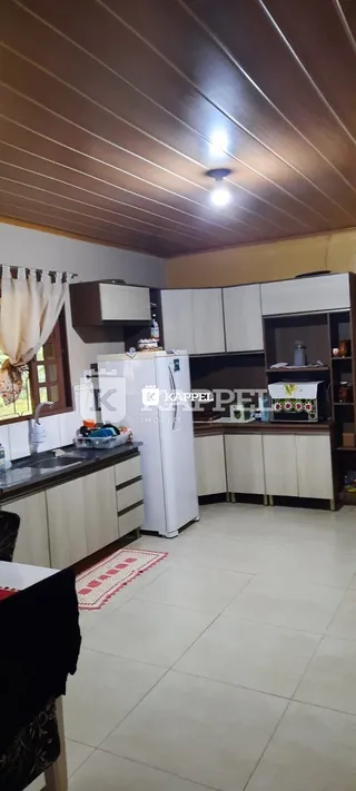 Esta é uma foto de uma cozinha com armários brancos e piso de cerâmica.