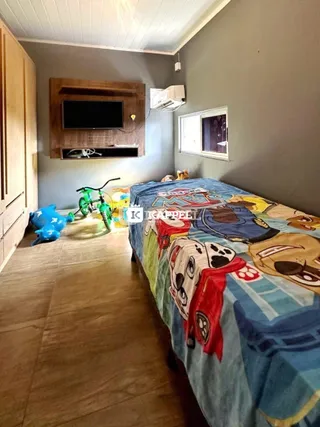 Quarto com cama grande e cabeceira de madeira em um ambiente interno.