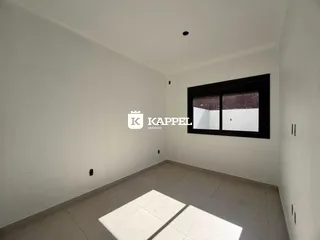 Foto de um cômodo interno com paredes brancas e piso de cerâmica.