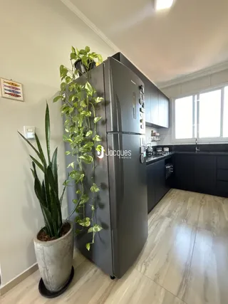 Cozinha moderna com geladeira grande e plantas decorativas.