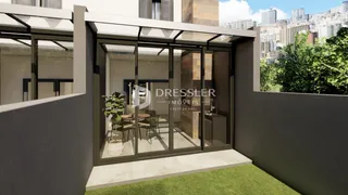 A fachada de uma residência com portas de vidro se abre para um jardim.