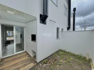 Fachada de uma residência branca com entrada de vidro em Lajeado, Brasil.