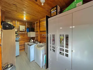 Interior de um cômodo com revestimento de madeira e armários brancos.