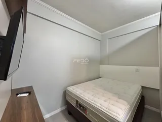 Quarto com cama e paredes brancas em um imóvel no Brasil.