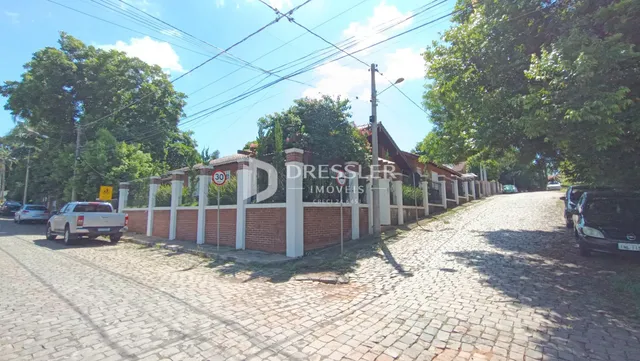 Vista da fachada de uma propriedade em Lajeado, Brasil, com muro de tijolos e cerca.