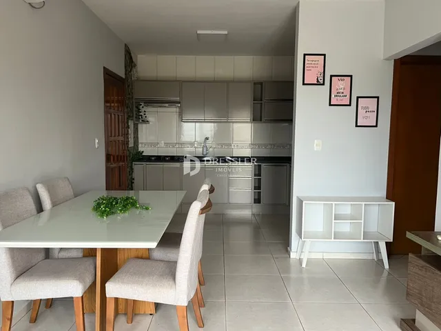 Ambiente interno de uma sala de jantar integrada com a cozinha.