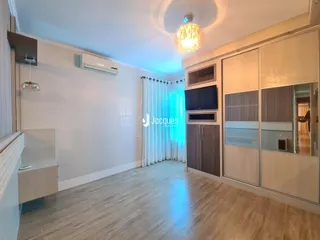 Sala de estar com piso de madeira e armários embutidos.