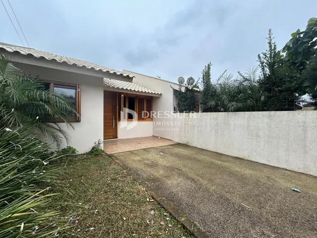 Fachada de uma residência em Lajeado, Brasil, com jardim frontal e muro branco.