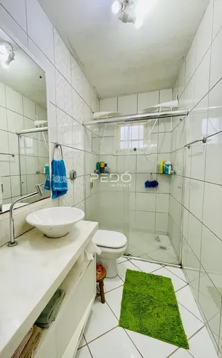 Foto de um banheiro com revestimento cerâmico branco.