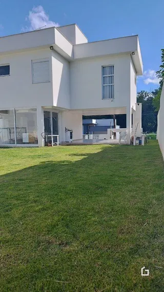 Fachada de uma casa branca em Lajeado, Brasil, com gramado verde.
