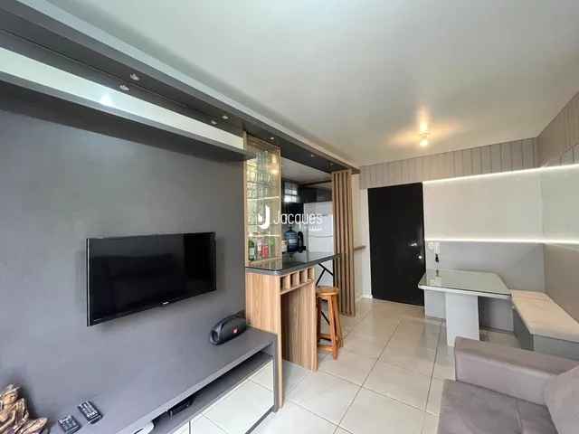 Sala de estar com televisão e móveis modernos.