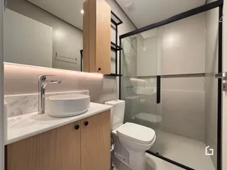Foto de um banheiro moderno com box de vidro e bancada de madeira.