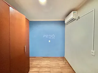 Um corredor interno com paredes azuis e piso de cerâmica.