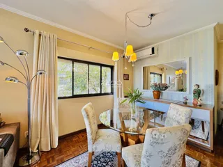 Sala de jantar com piso de madeira e grande janela em um imóvel no Brasil.