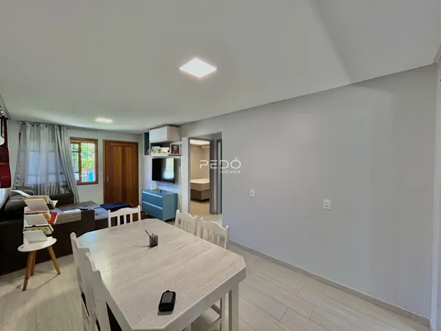 Foto de uma sala de jantar com piso claro e portas de madeira em um imóvel no Brasil.