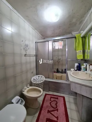 A foto mostra o interior de um cômodo com revestimento de azulejos brancos.