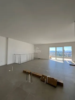 Uma sala ampla e vazia com vista para o exterior.