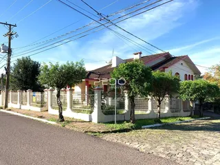 Vista da fachada de uma casa em Lajeado, Brasil, com cerca e árvores.