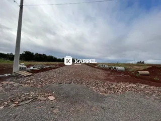 Foto externa de um terreno com terra e tubulações em uma área rural.