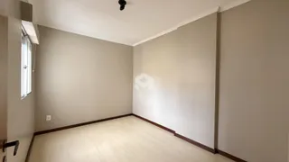 Vista interna de um ambiente com piso de madeira clara e paredes neutras.