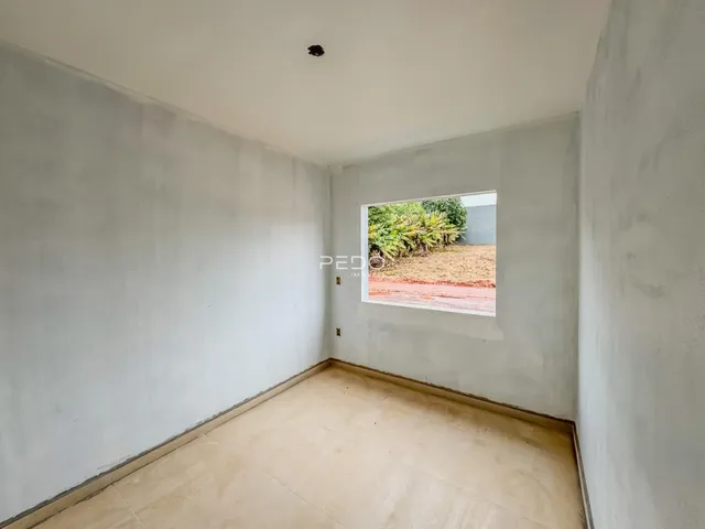 Parede interna de uma residência com piso de cerâmica e abertura para o exterior.