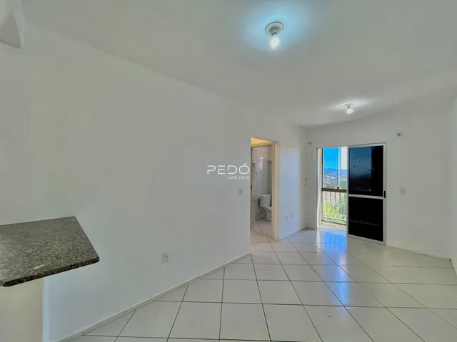 Ambiente interno de uma sala com piso de cerâmica branca.