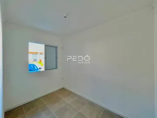 Interior de um cômodo com piso de cerâmica e janela.