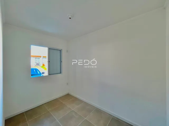Interior de um cômodo com piso de cerâmica e janela.