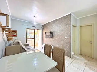 Sala de estar com mesa de jantar e porta de vidro abrindo para o exterior.