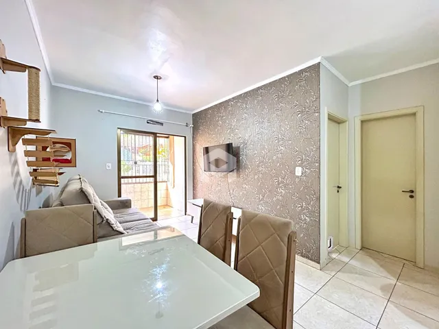 Sala de estar com mesa de jantar e porta de vidro abrindo para o exterior.