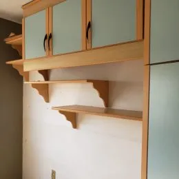 Armários de madeira instalados na parede de uma cozinha.