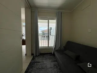 Sala de estar com vista para o exterior através de uma grande janela.