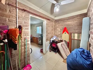 Hall de entrada com paredes de tijolo aparente em uma residência.