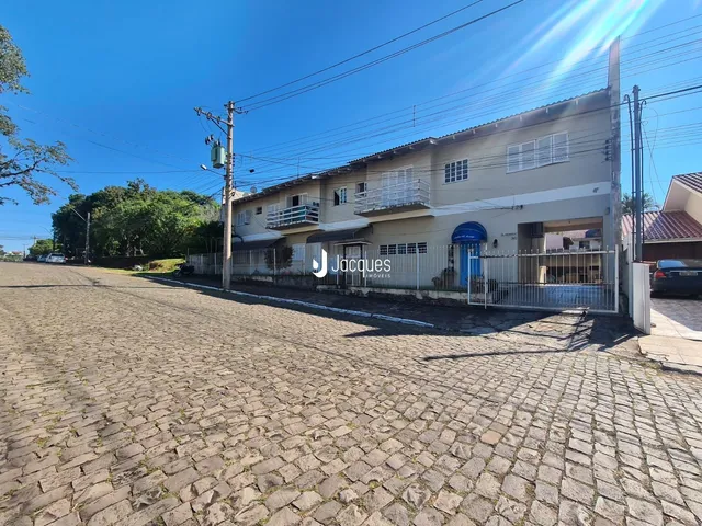 Fachada de uma casa em Lajeado, Brasil, com muro e calçada de paralelepípedos.