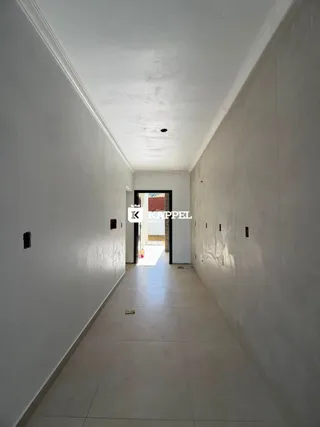 Corredor longo e branco com portas no final.