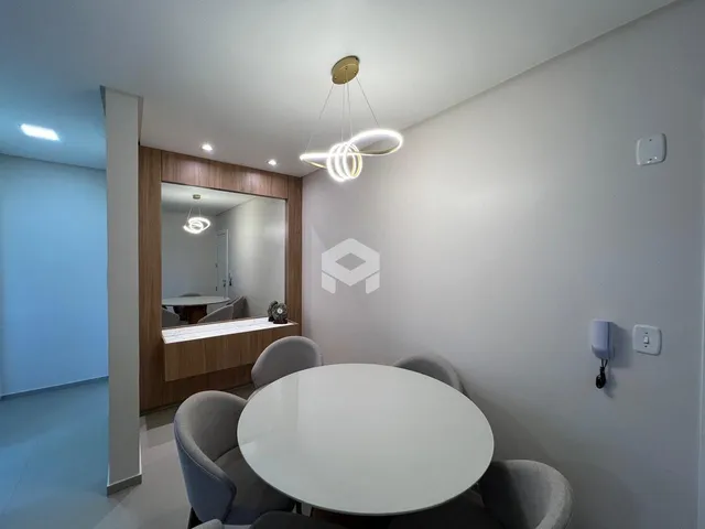 Uma sala de jantar moderna com mesa redonda e cadeiras cinzas.