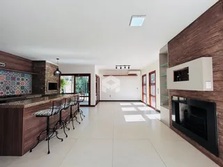 Ambiente interno de uma sala de estar com área de jantar e cozinha em Lajeado.