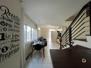 Interior de uma sala de estar com piso de cerâmica e escadaria.