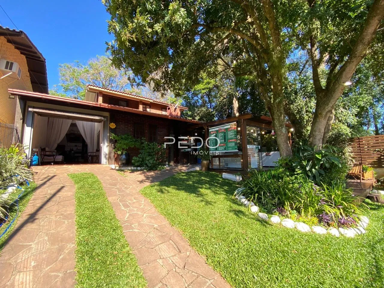 Fachada de uma residência com jardim e entrada de garagem em Lajeado, Brasil.