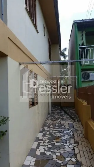 Vista de um pátio pavimentado entre duas edificações.