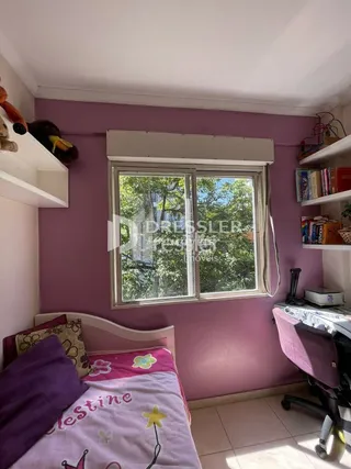 Quarto com paredes roxas e janela em um imóvel no Brasil.