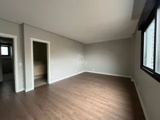 Sala de estar com piso de madeira e paredes cinzas em um imóvel.