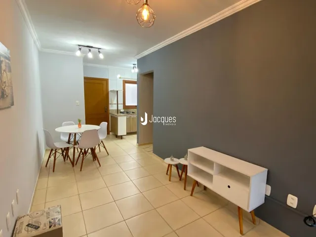 Interior de uma sala de jantar com piso de cerâmica clara e parede cinza.