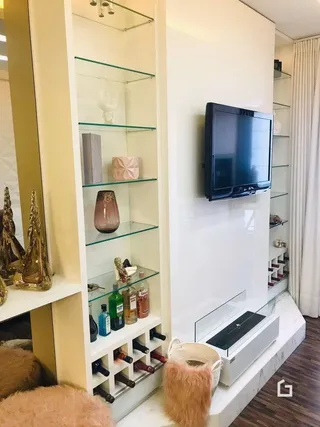 Hall com nichos e televisão montada na parede.